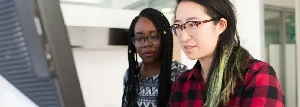 Two women looking at a computer screen together